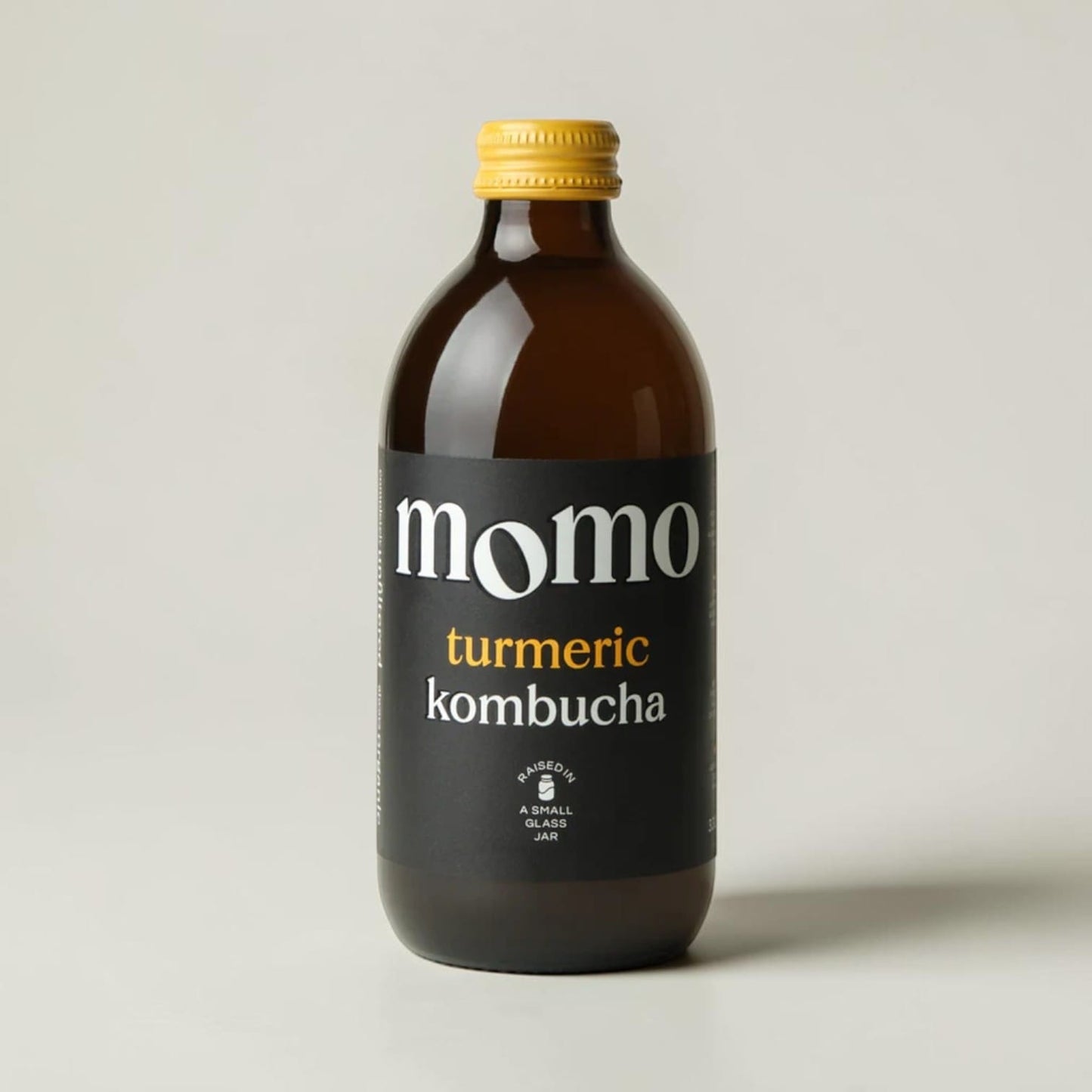 Momo organic turmeric kombucha in a glass bottle with a yellow cap, sold by Saporia | Artisan UK Vegan Cheesemonger & Deli