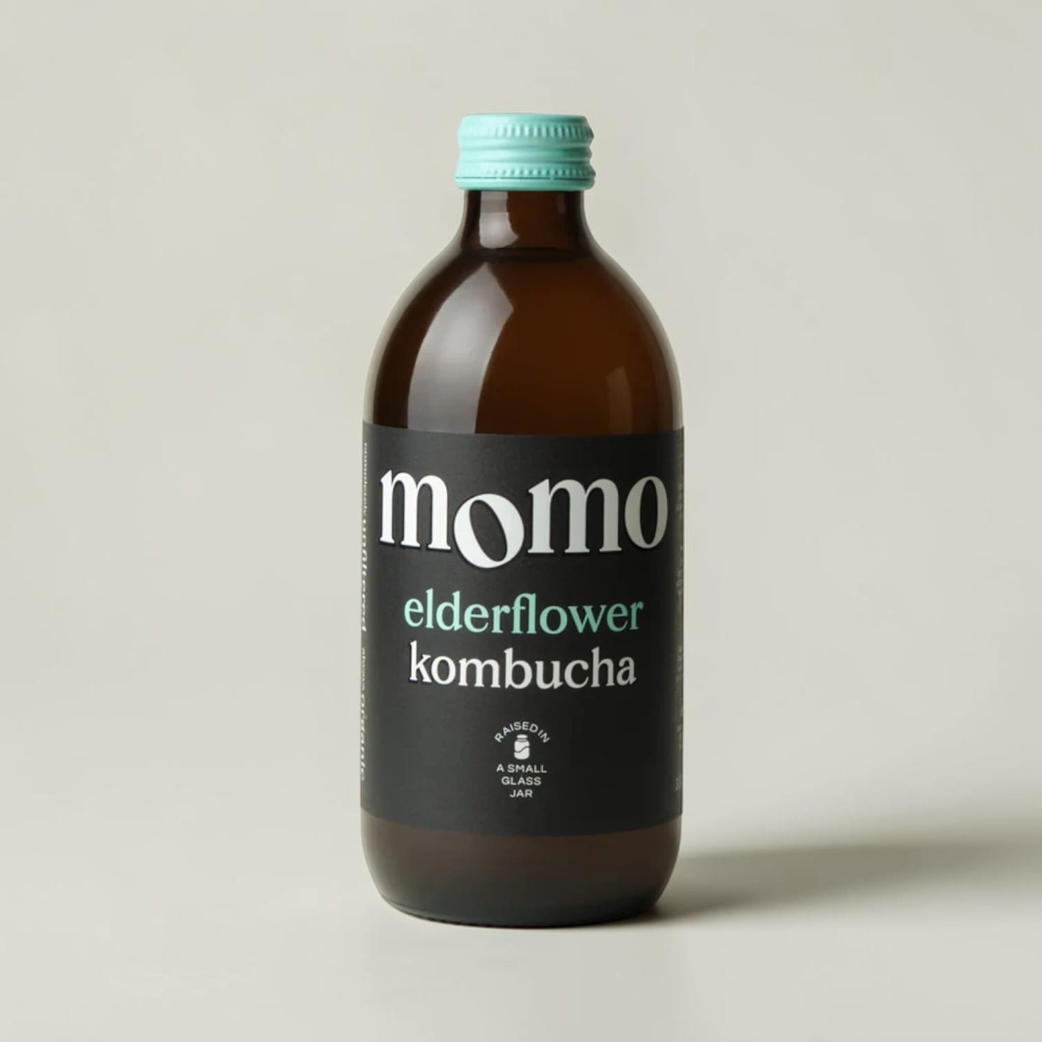 Momo organic elderflower kombucha in a brown glass bottle with a teal cap, sold by Saporia | Artisan UK Vegan Cheesemonger & Deli