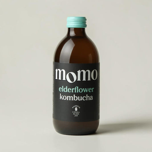 Momo organic elderflower kombucha in a brown glass bottle with a teal cap, sold by Saporia | Artisan UK Vegan Cheesemonger & Deli
